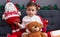 Adorable hispanic boy holding balls sitting on sofa by christmas decoration at home