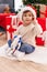 Adorable hispanic boy playing with robot toy sitting on floor by christmas tree at home