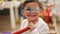 Adorable hispanic boy wearing halloween costume inflating balloon at kindergarten