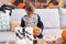 Adorable hispanic boy wearing skeleton costume drawing on pumpkin at home