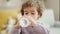 Adorable hispanic girl drinking water standing at home