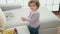 Adorable hispanic girl playing with money standing at home