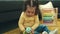 Adorable hispanic girl playing with toy sitting on sofa at home