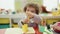 Adorable hispanic girl preschool student sitting on table drawing on paper at kindergarten