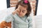 Adorable hispanic girl sitting on bed waking up at bedroom