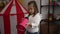 Adorable hispanic girl using megaphone standing at kindergarten