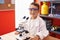 Adorable hispanic toddler student using microscope standing at classroom