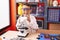 Adorable hispanic toddler student using microscope standing at classroom