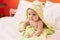 Adorable hispanic toddler wearing funny towel sitting on bed at bedroom