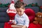 Adorable hispanic toddler writing letter to santa claus sitting on sofa by christmas decoration at home
