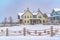 Adorable homes beyond a rope fence on the snow covered ground in winter