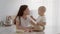 Adorable Infant Baby Feeding Mom With Strawberry While Having Snacks In Kitchen