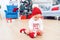 Adorable infant sits on the floor and playing with christmas tree ball. Happy winter holidays concept. Christmas and New