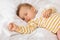 Adorable innocent little girl sleeping on bed with good dream, infant baby feeling comfortable, selective focus on hand