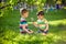 Adorable kid boy making fire on paper with a magnifying glass outdoors, on sunny day.