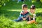 Adorable kid boy making fire on paper with a magnifying glass outdoors, on sunny day