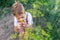 Adorable kid boy is on a summer garden and smelling yellow fennel. Walking in the farm.