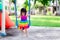 Adorable kid girl playing swing on playgrounds. Baby child wearing colorful dresses