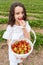 Adorable kid girl in white dress enjoying delicious strawberries at farm field.