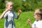 Adorable kids blow bubbles outdoors