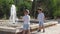 Adorable kids, brothers watching the fountain. Older brother dropping stone in it