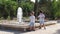 Adorable kids, brothers watching the fountain. Older brother dropping stone in it