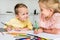 adorable kids smiling each other while drawing with colored