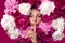 Adorable lady with fresh skin surrounded with peony flowers, keeping finger near lips, calls on to keep silence, woman with