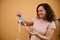 Adorable Latin American pregnant woman, smiling, holding ironed laundred newborn baby cap in the dressing room