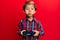 Adorable latin kid playing video game holding controller puffing cheeks with funny face