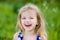 Adorable laughing little girl with long blond curly hair,