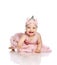 Adorable laughing little infant baby girl toddler in pink dress, crown on head is creeping on floor towards camera