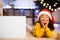Adorable little afro girl in Santa hat lying next to blank poster