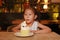 Adorable little Asian child girl blowing happy birthday cake 4 years old