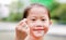 Adorable little Asian child girl making mini heart sign by thumb and forefinger for i love you. Focus at her finger