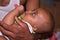 Adorable little Baby get medicine from feeding tube on daddy`s lap. selective focus on hands