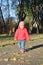 Adorable little baby girl walking in the autumn park