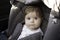 Adorable little baby sitting in car ready to ride with parents