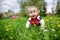 Adorable little blond child with blue eyes laying on the grass