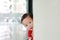 Adorable little boy hide behind a corner room. Baby playing peekaboo game indoor