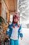 Adorable little boy with lantern, standing in front of a winter