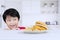 Adorable little boy peeking a delicious hamburger