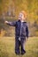 Adorable little boy standing on autumn landscape