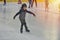 Adorable little boy in winter clothes with protections skating o