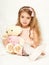 Adorable little child girl sit in the bed with her toy. The child girl hugs the teddy bear.