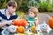 Adorable little child and his father making jack-o-lantern for