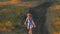 Adorable little girl in blue summer dress climbing up the hill. Child running in wild grass countryside landscape. Family walking