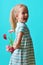 Adorable little girl with cheeky smile and face expression holding bouquet of pink gerbera daisies. Happy Mother`s Day.