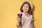 Adorable little girl with delicious ice cream, space for text