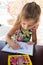 Adorable little girl drawing artwork top view on crayons in a notebook, Baby healthy and preschool concept